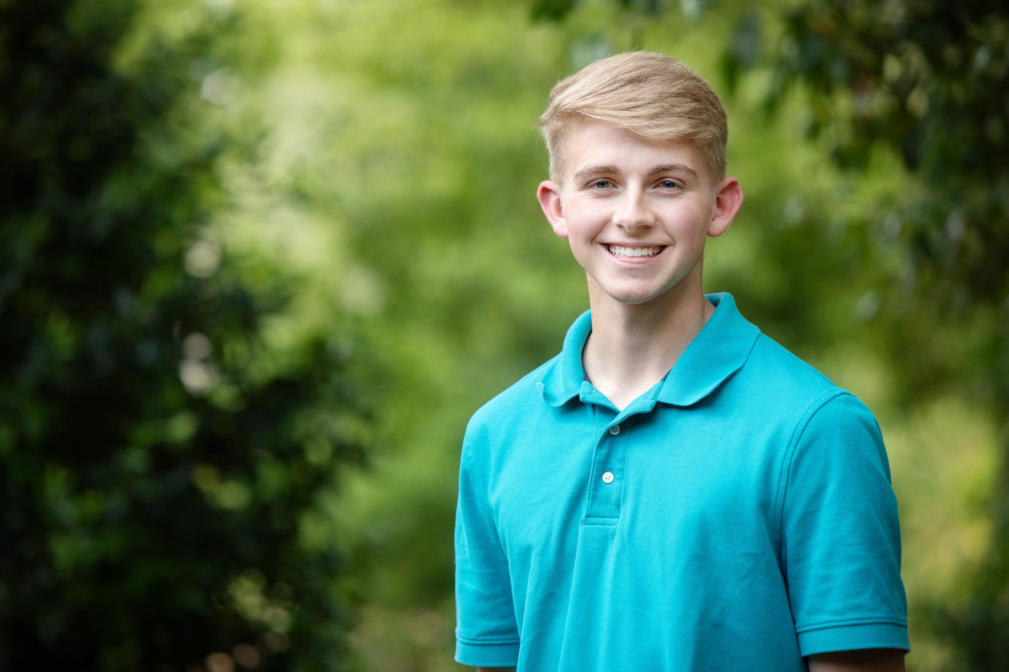 young boy, blue polo shirt, green background