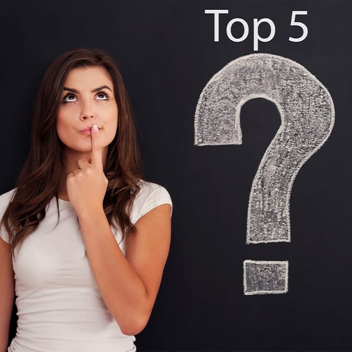 Woman standing in front of chalkboard with top 5, top 5 invisalign concerns Spillers Orthodontics